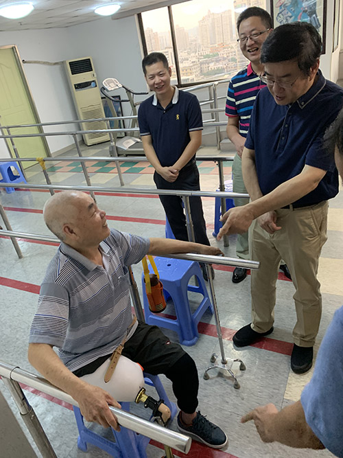 图为与正在进行假肢训练的残疾人亲切交谈