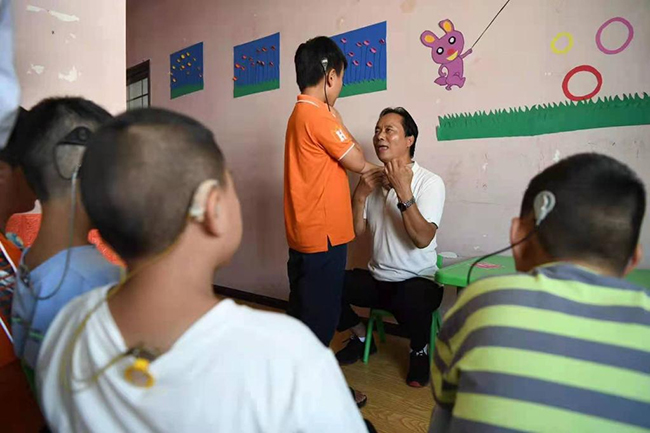 赵小平在给听障儿童做发音练习
