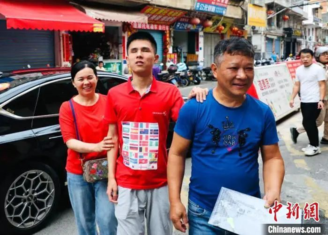 图为6月7日黄镇宇在父母的陪伴下准备进入考点