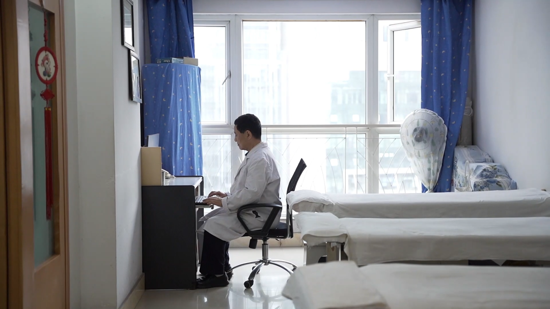 图为黄维乾用电脑编写盲人按摩教材
