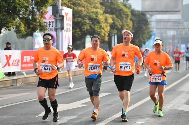 图为视障跑者张军在陪跑员的带领下参加马拉松