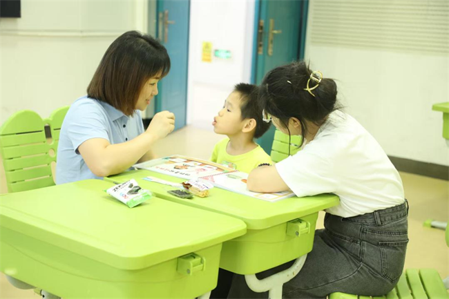 图为康复教师开展言语训练