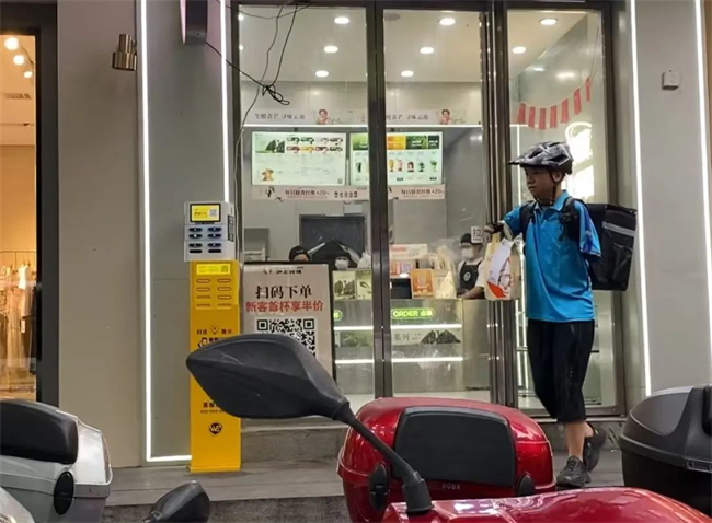 图为李向阳正在送外卖