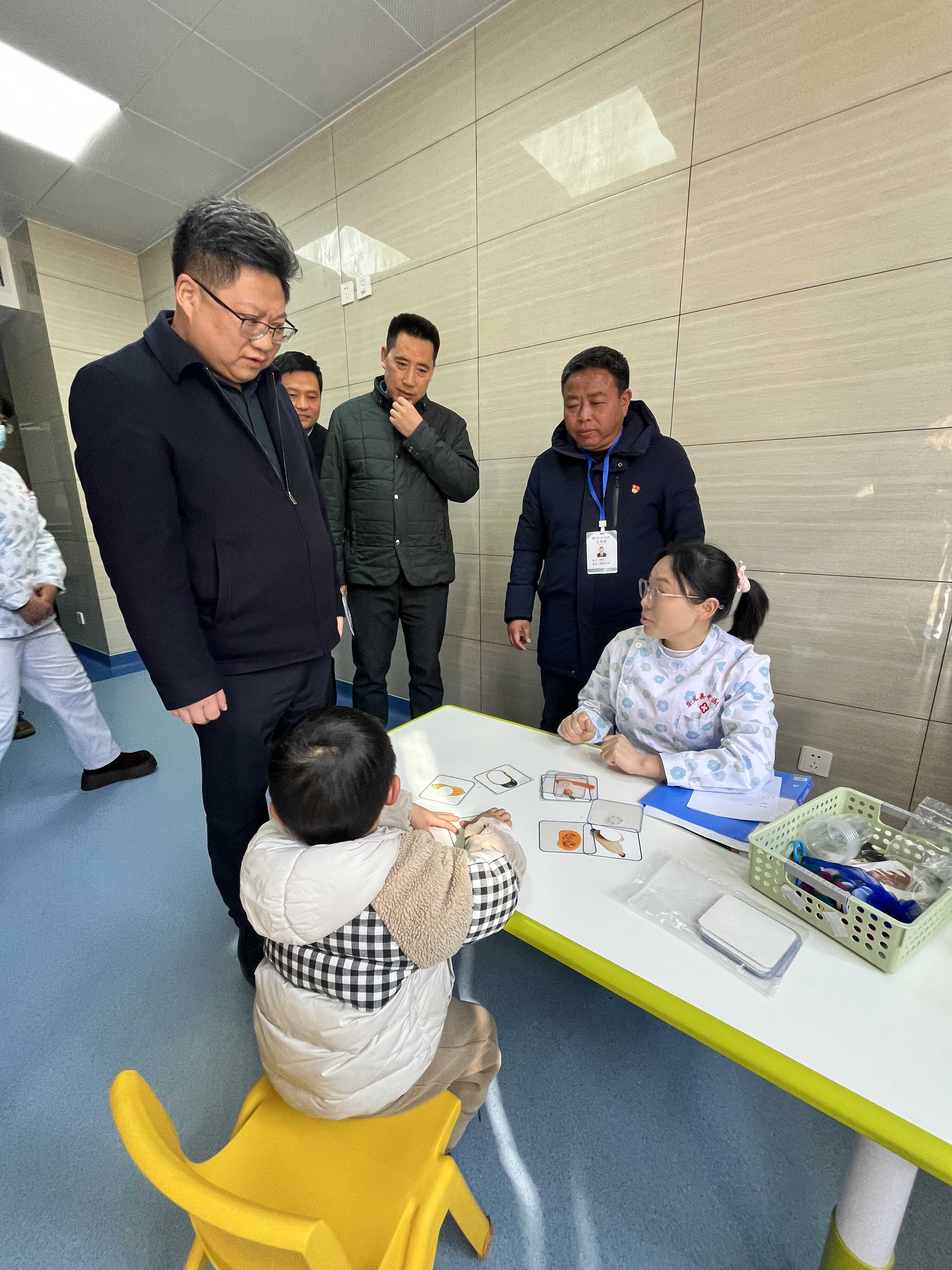 图为周代军与残疾儿童家长交流