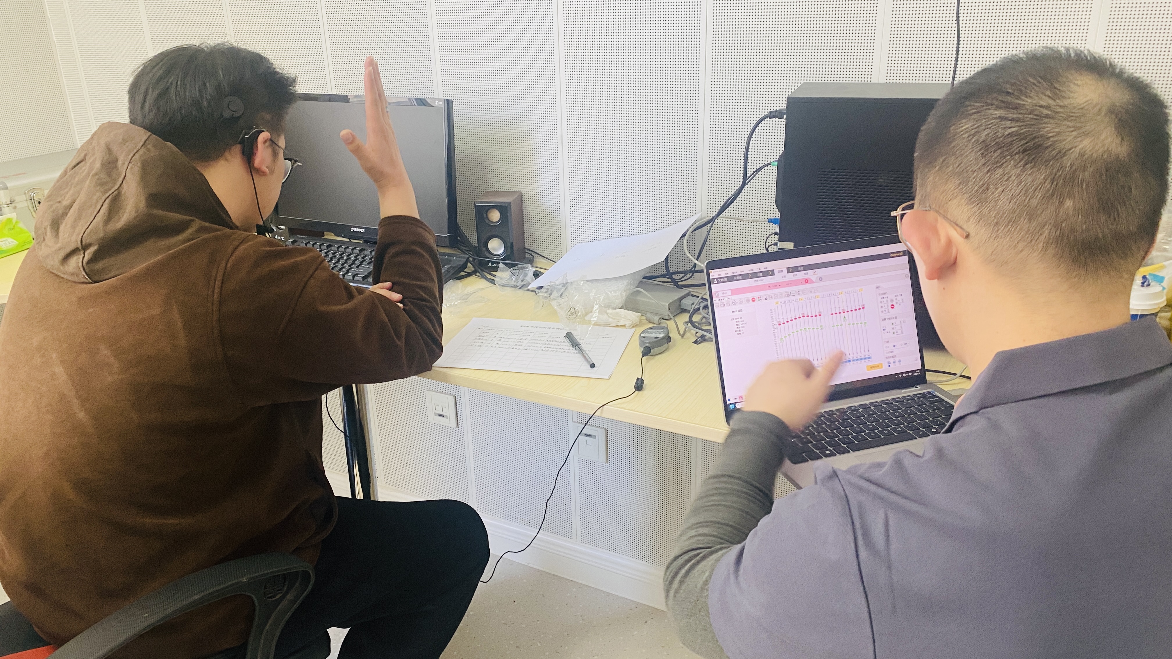 图为技术人员为人工耳蜗佩戴者进行调试