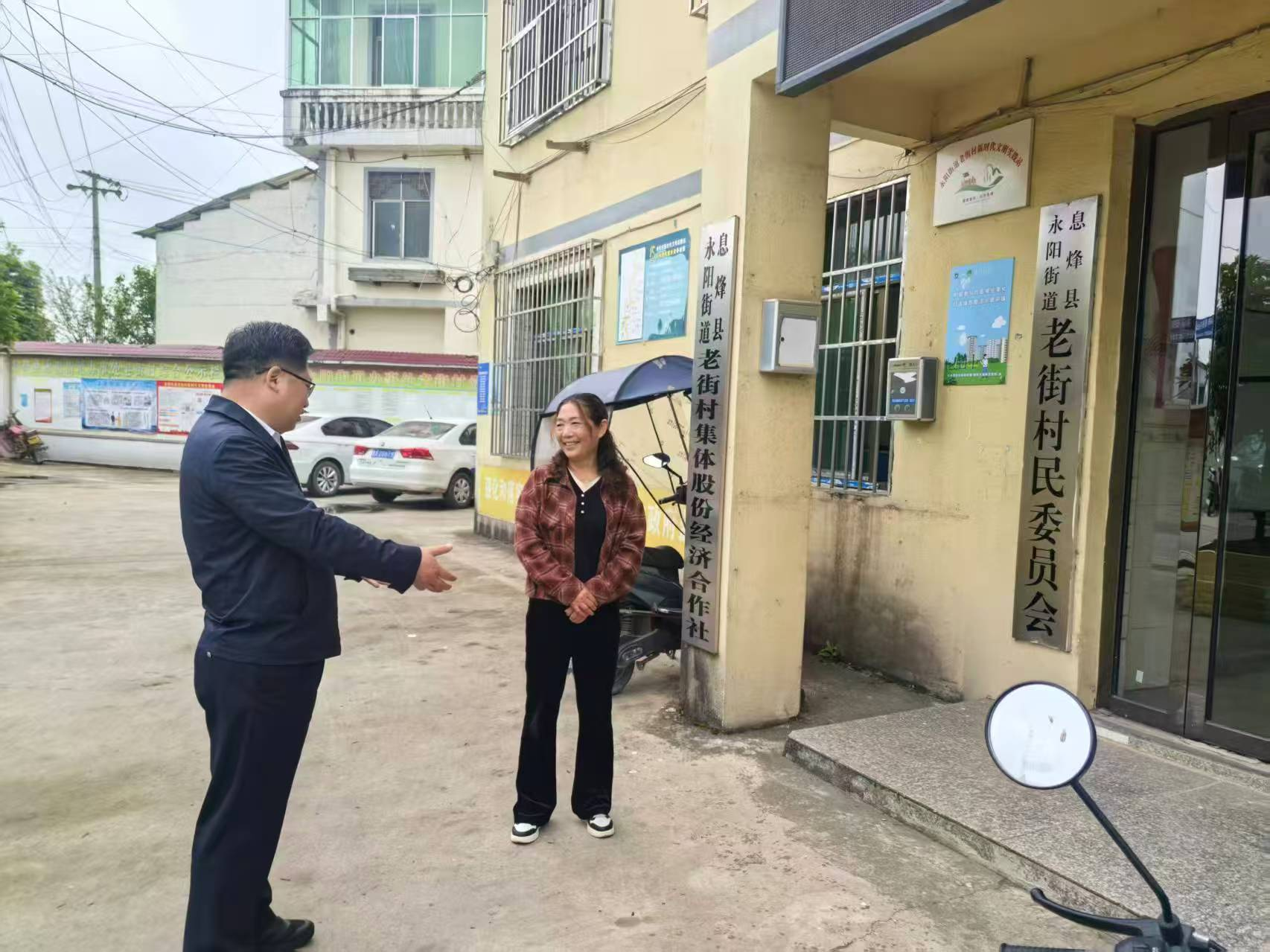 图为周代军与残疾人专职委员亲切交谈