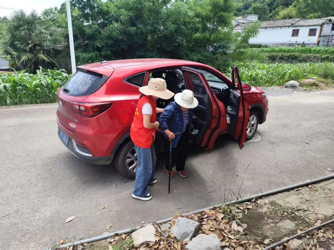 图为志愿者接行动不便的老人